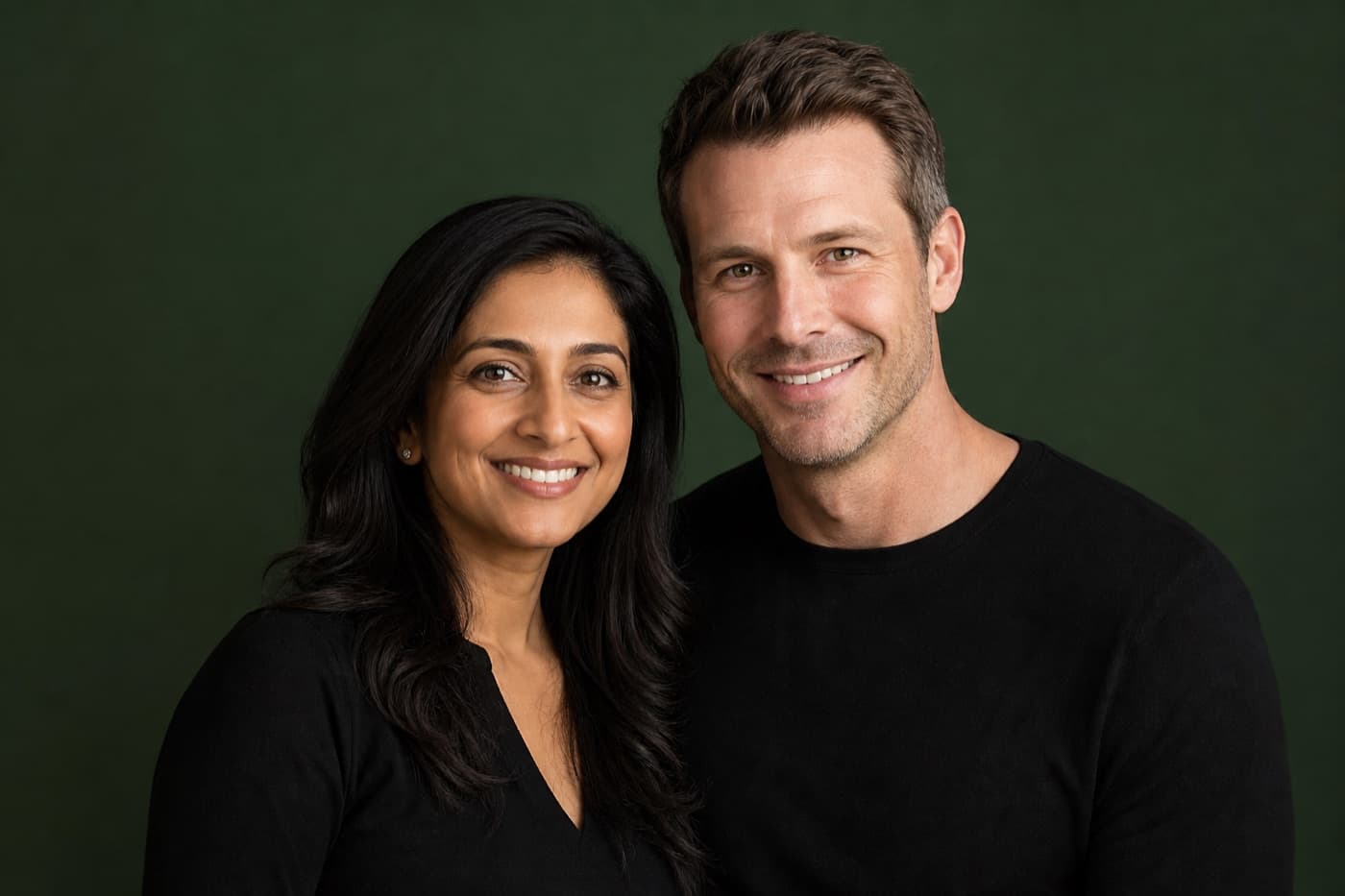 Connected couple in a forest green studio portrait, confident wellness